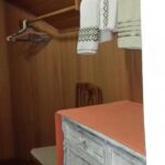 Pequeno corredor em frente ao banheiro com espaço para guardar seus utensílios