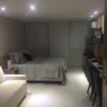 Ambiente com sala e cama de casal queen